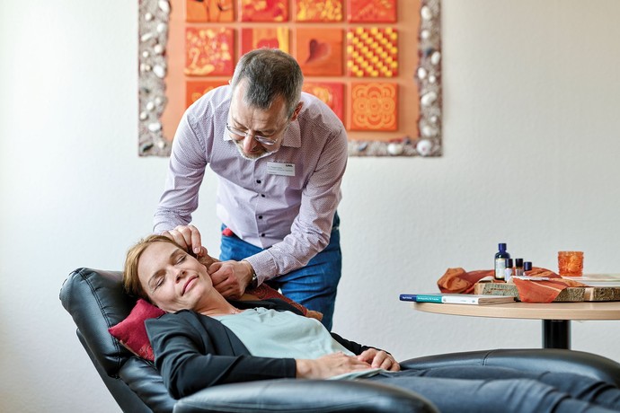 Eine Frau liegt auf einem Liegesessel und erhält eine Akkupunktur-Behandlung