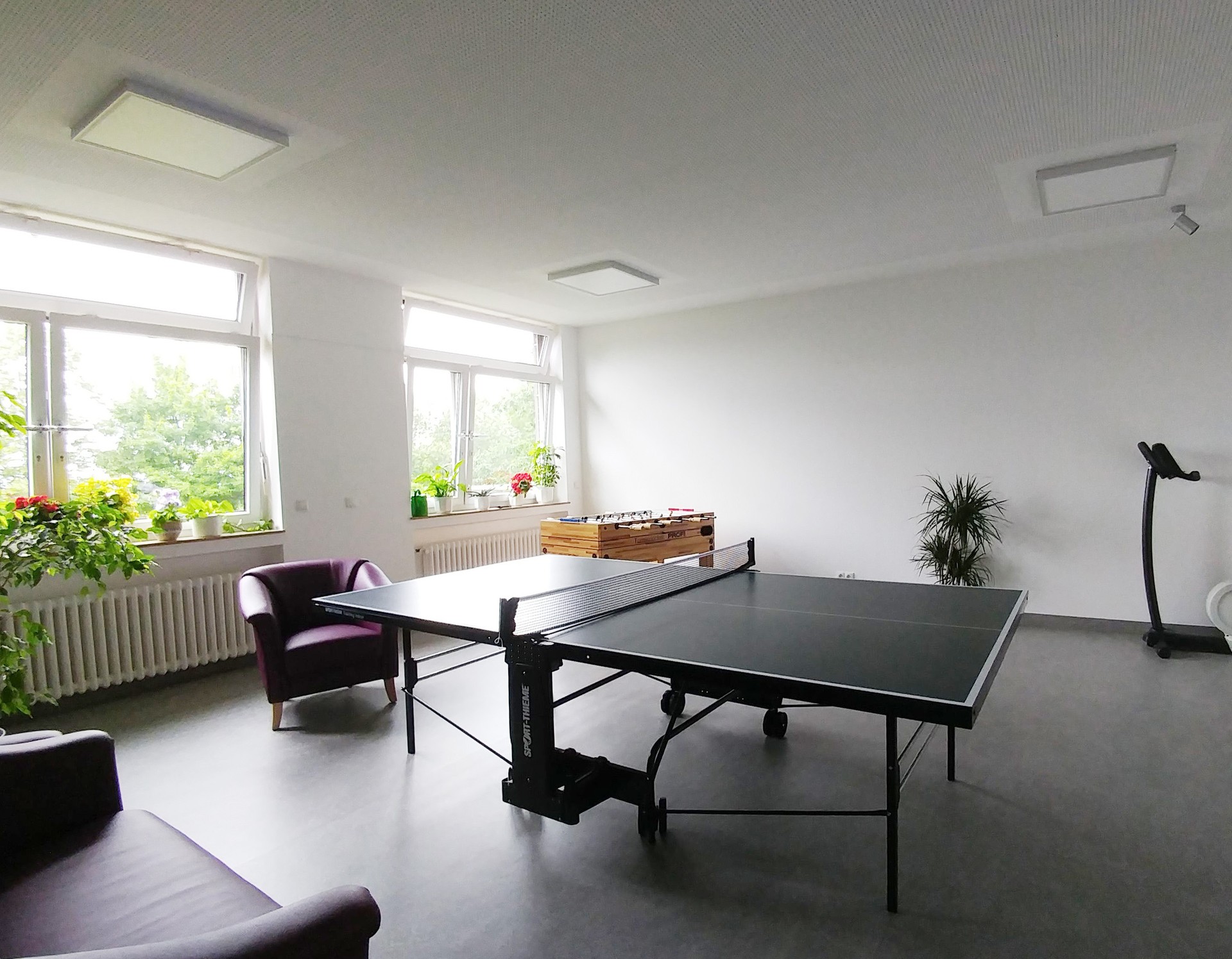 In einem Raum mit Fenstern steht eine Tischtennisplatte, dahinter ein Kicker und Stepper und ein Sofa. Foto: Dr. Bernward Siegmund