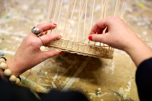Frauenhände flechten einen Korb