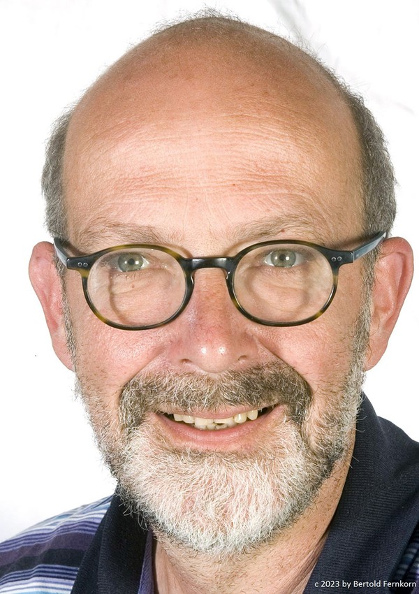 Gesicht eines Mannes mit Brille und grauem kurzem Bart