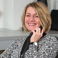 Frau mit blonden kurzen Haaren telefoniert