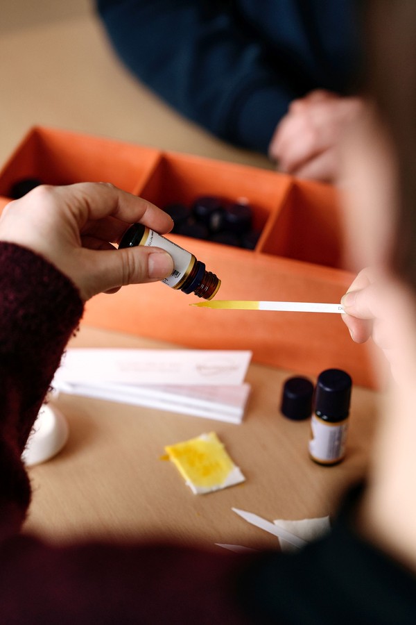 Aromaöl wird aus einem Fläschchen auf einen Papierstreifen getropft