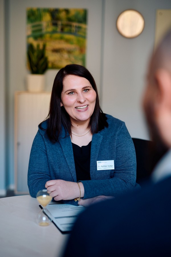 lächelnde Frau mit dunklen, schulterlangen Haaren