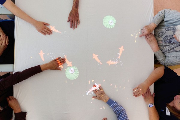 Hände fangen auf einen Tisch projezierte Fische