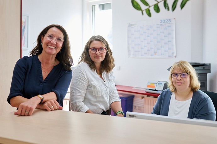 Drei Frauen lächeln am Empfang