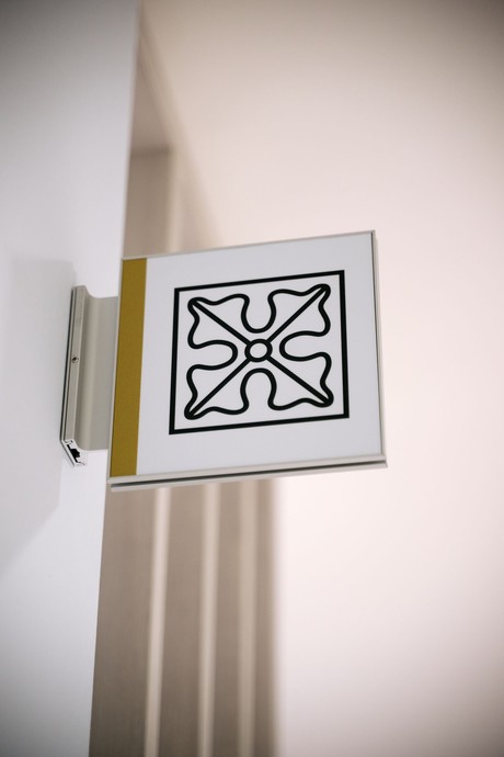 Schild an der Wand mit einem Ornament-Symbol (vergrößerte Bildansicht wird geöffnet)