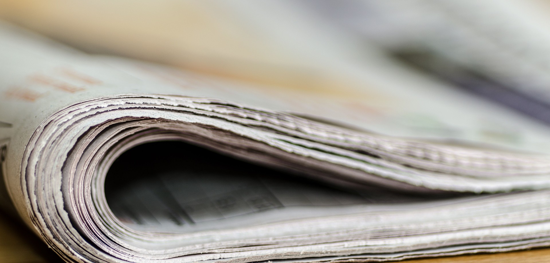 Eine zusammengefaltete Zeitung liegt auf einem Tisch