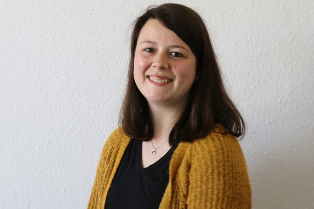 Eine lächelnde junge Frau mit dunklem, schulterlangem Haar Eine lächelnde junge Frau mit dunklem, schulterlangem Haar