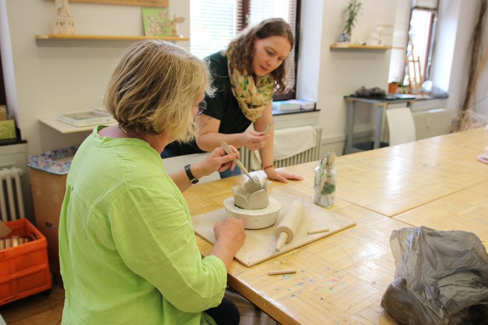 Frauen formen zusammen etwas aus Ton