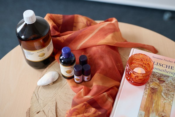 Aromaöl-Fläschchen auf einem Tisch mit orangenem Tuch