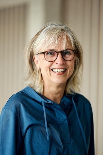 Eine Frau mit schulterlangen blonden Haaren und einer dunklen Brille lächelt. Foto: Nikolaus Urban
