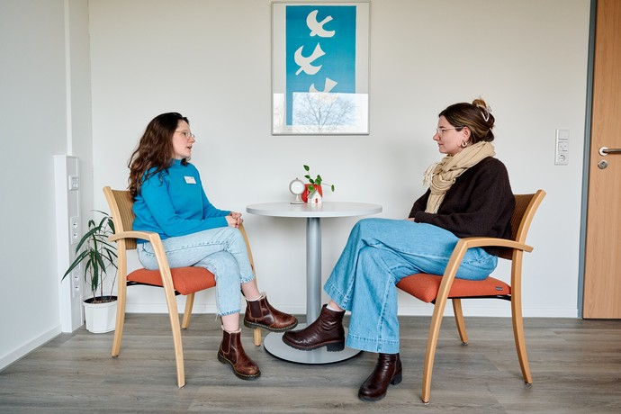 Zwei Frauen unterhalten sich an einem kleinen Tisch