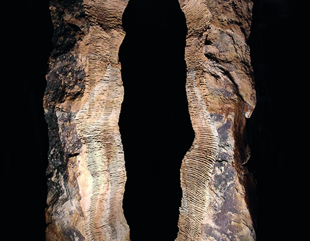 Zwei etwa zwei Meter hohe Sandsteinstelen mit zahlreichen waagerechten Einschnitten