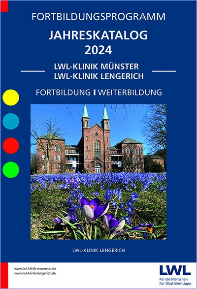 Ein rotes Backsteingebäude mit zwei hohen Türmen, davor ein Rasen mit vielen blauen Frühlingsblumen