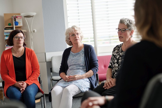 Menschen sitzen in einer Gesprächsrunde