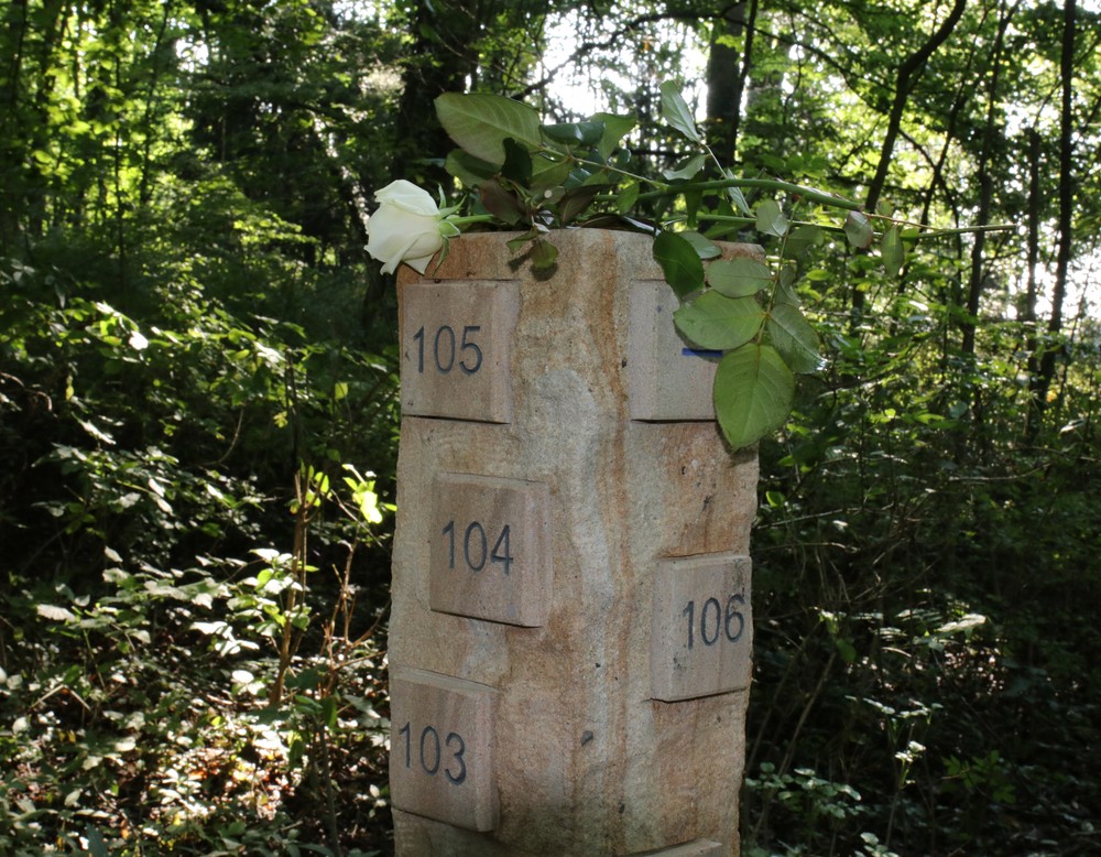 Eine Sandsteinsäule mit einer Zahl und einer weißen Rose